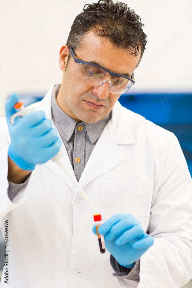 Mature Hispanic scientist working at his laboratory Mature Hispanic scientist working at his laboratory