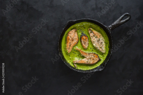 Fish in green curry on black background. 