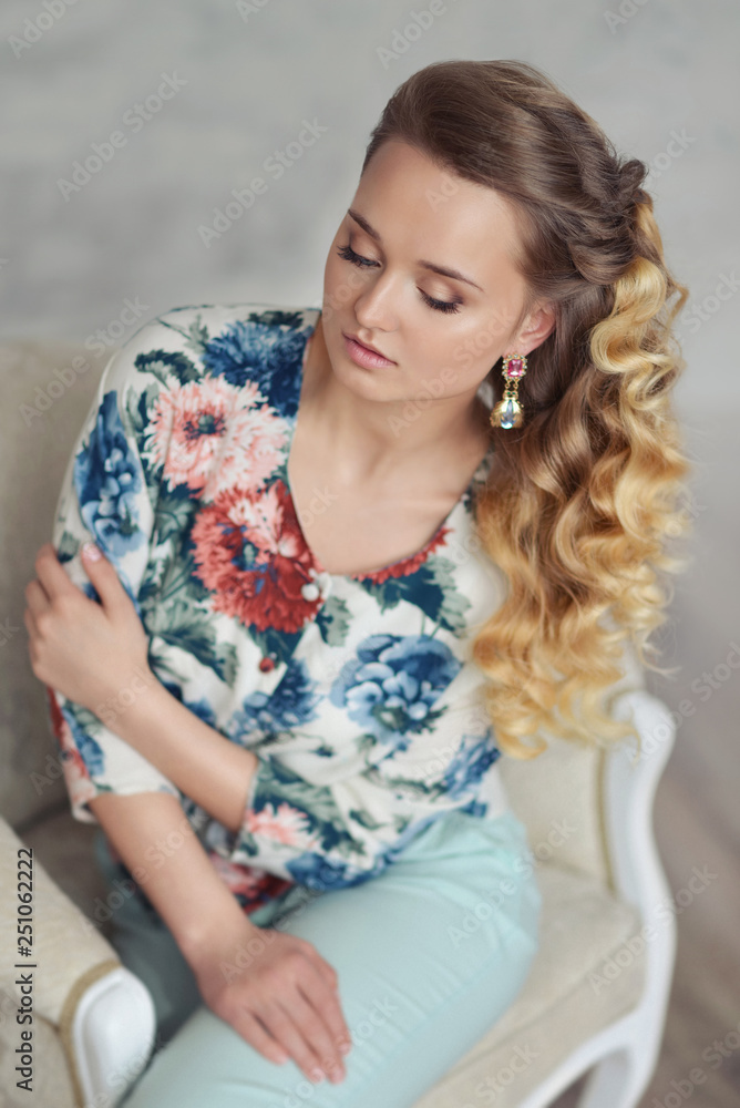 Naklejka premium portrait of a beautiful young woman with blond curly curls tender elegant girl with expressive blue eyes in the studio. Fashion photo