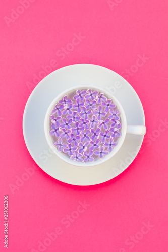 Cup of beautiful lilac flowers infused water