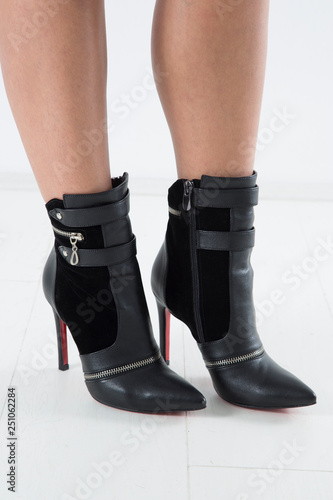 Fototapeta Naklejka Na Ścianę i Meble -  Side View Of Elegant Black Leather High Heels Pointed Boots With Straps And Zippers, Studio Shot Over White Background