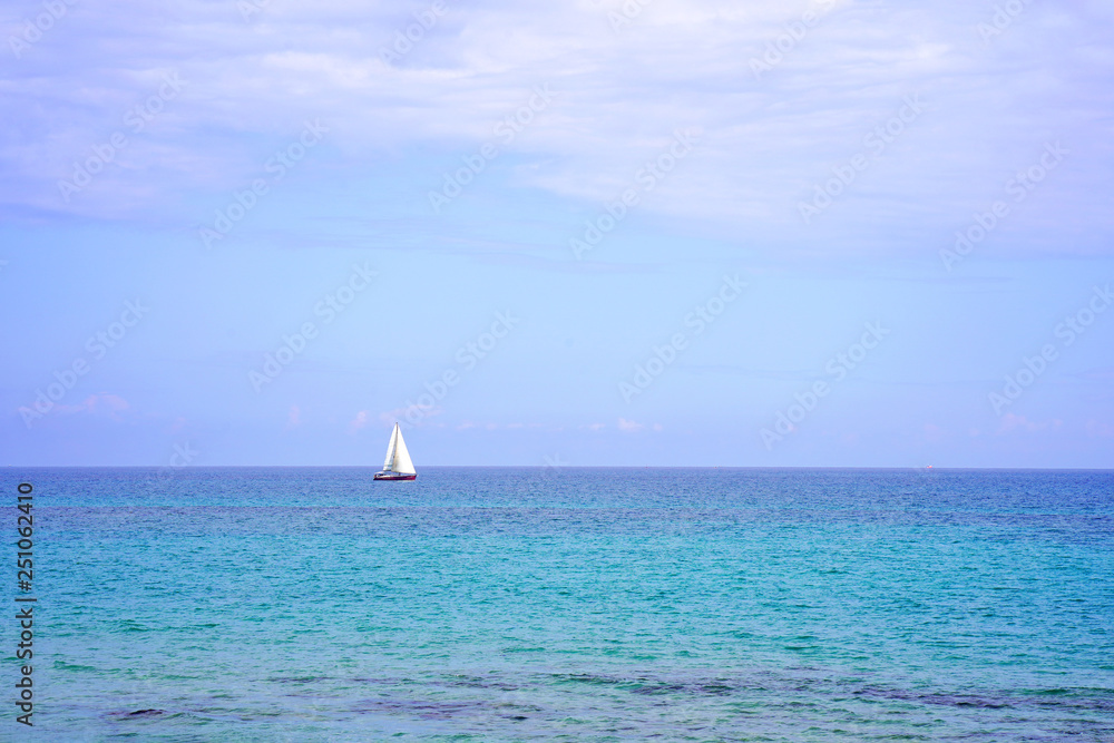 Obraz premium Yacht on the sea horizon on a summer day