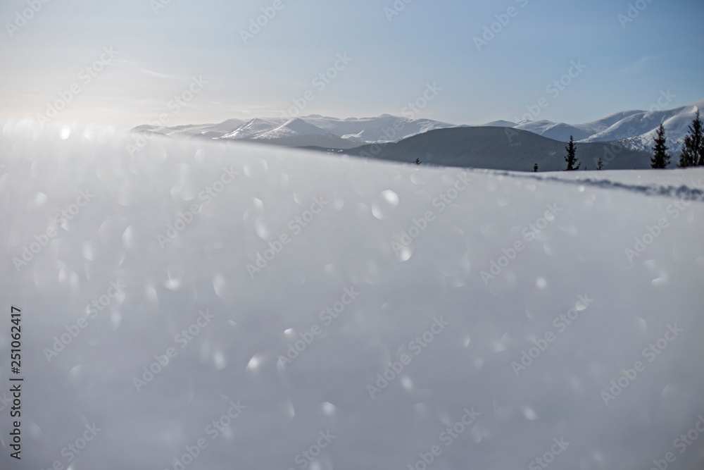 The wonderful winter landscape of the Carpathians with a blurred foreground and superb bokeh of snow cover in the sun. 