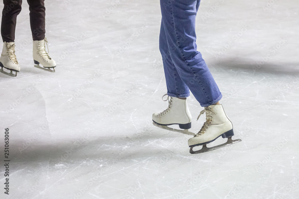 feet on the skates of a person rolling on the ice rink