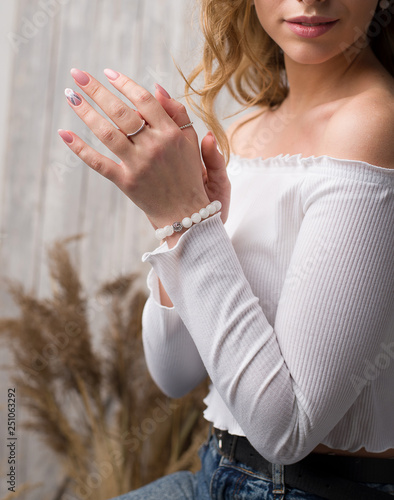 on the hand of the girl is a bracelet made of moonstone, on the arm is a bracelet made of white stones
