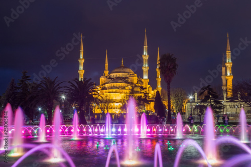 fountain with blue illumination on Sultanahmet square in front of the Blue mosque (Sultan Ahmed Mosque)in Istanbul in the evening