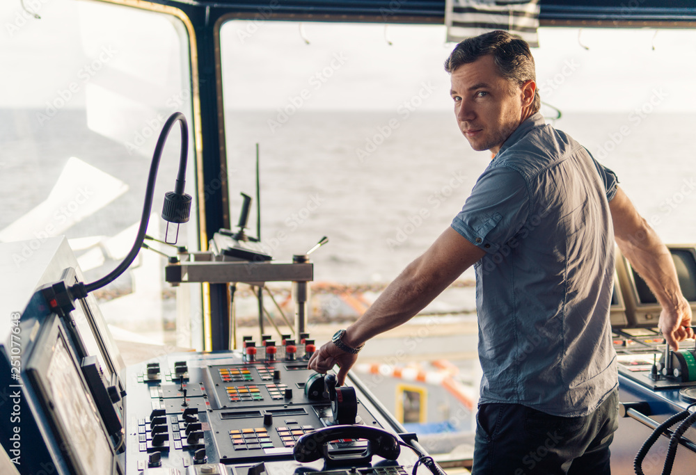 Marine navigational officer during navigational watch on Bridge . Work at sea Marine navigational officer during navigational watch on Bridge . Work at sea