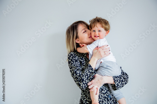 Mother and son on a white wall background at home