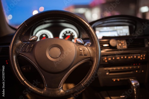 interior, steering wheel of a modern business car in the evening. backlight panel. © velimir