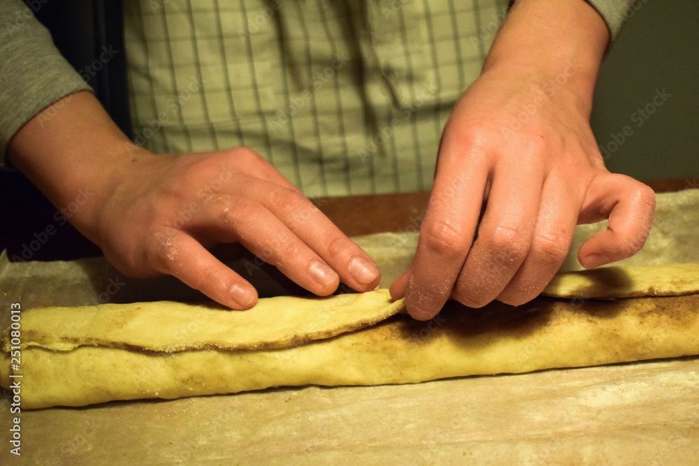 Confectioner at work with the dough. Hands close-up. Making cinnamon rolls. Traditional Swedish and Norwegian pastries.
