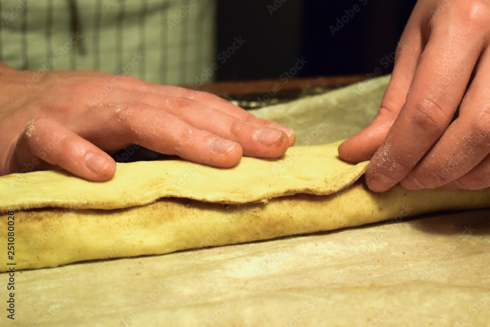 Confectioner at work with the dough. Hands close-up. Making cinnamon rolls. Traditional Swedish and Norwegian pastries.