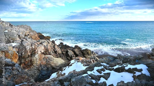 Snowy and rocky overlook of the ocean and coast during winter in Massachusetts