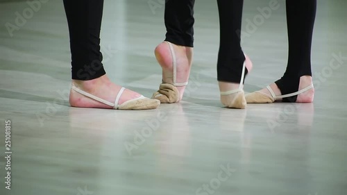 Close-up feet of ballerinas in pointe perform dance ballet elements and different exercises in sport gym for rhythmic gymnastics