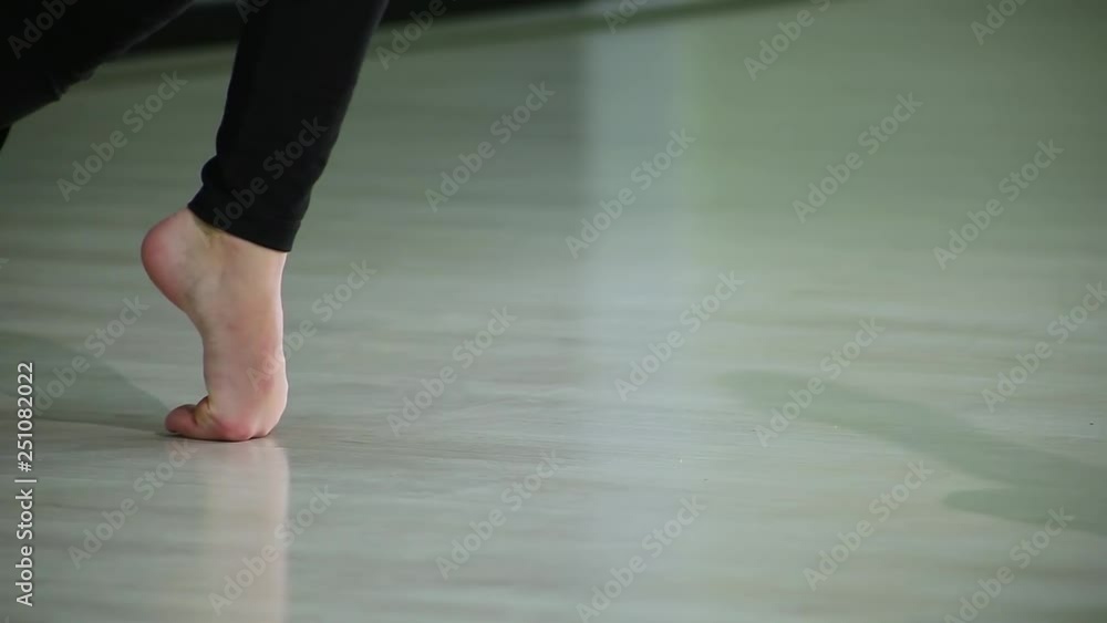 Close-up feet of ballerinas perform ballet elements and different exercises in sport gym for rhythmic gymnastics Close-up feet of ballerinas perform ballet elements and different exercises in sport gym for rhythmic gymnastics