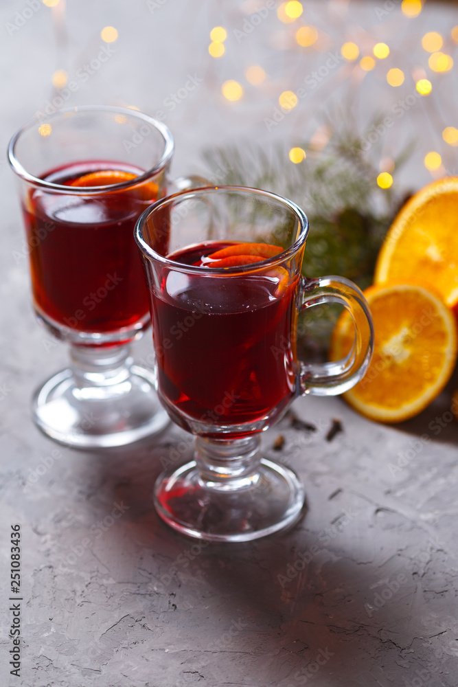mulled red wine with spices and orange on dark background. warming drink