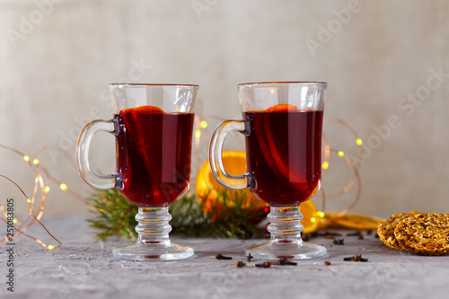 mulled red wine with spices and orange on dark background. warming drink
