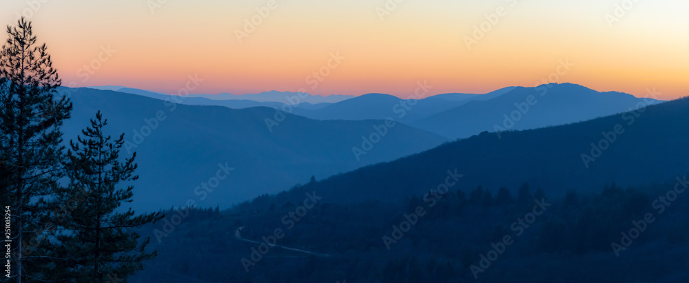 Panorama sur une chaîne de montagne en dégradé au coucher de soleil