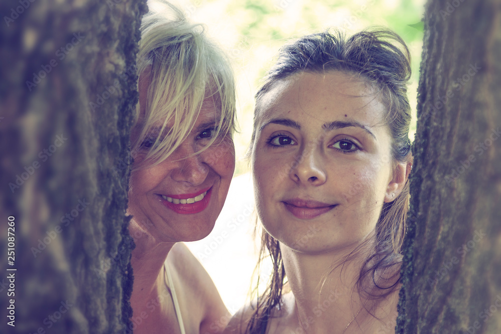 Naklejka premium mother and daughter while posing hugged together in swimsuit
