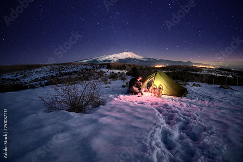 Man Near Illuminated Tent On The Snow Under Starry Sky photo