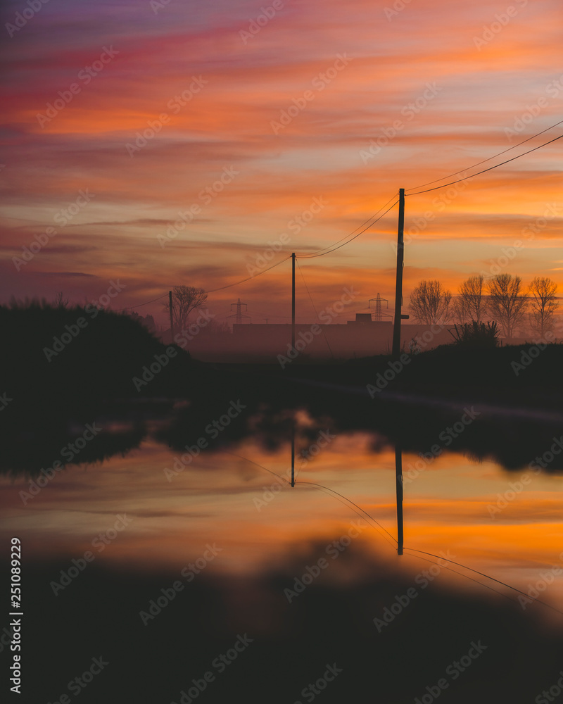 Sunset Sky Reflecting On Small Lake with Power Lines on Landscape, Afternoon Orange Purple Sky