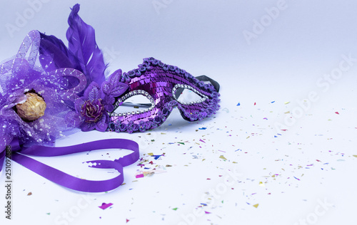 Violet masks on white background and violet flower and ribbon heart shape. Carnival or Carnival Sunday concept.