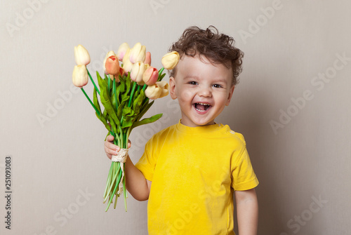 Young boy holding tulips isolated on white