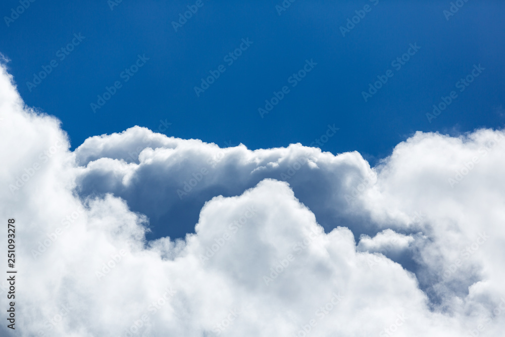 Blue sky covered in large puffy cumulonimbus cloud formations
