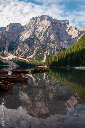 Lake of Braies, Italy. Classic view of the lake with the famous rowing boats and the reflection of the mountain "Croda del Becco" and the clouds on the water