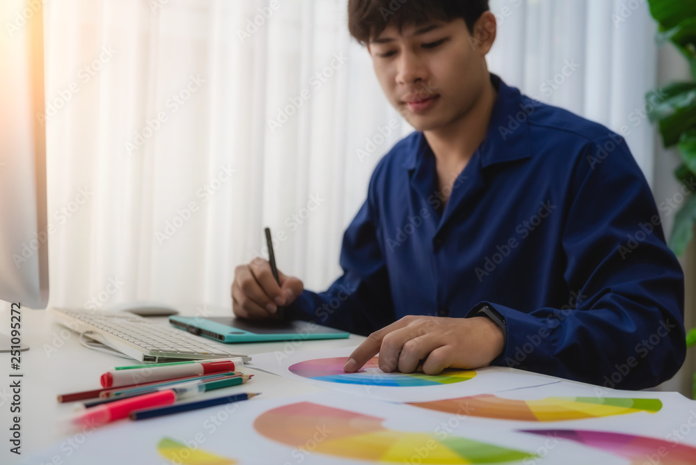 Graphic designer man creative using Color swatch samples for website layout and application for mobile phone in workplace. Graphic designer man creative using Color swatch samples for website layout and application for mobile phone in workplace.
