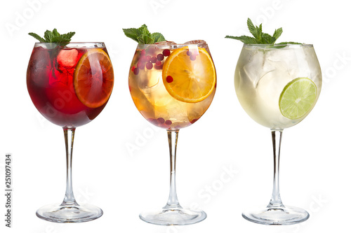 Alcoholic and non-alcoholic refreshing cocktails with mint, fruits and berries on a white background. Three cocktails in glass glasses on a long leg.