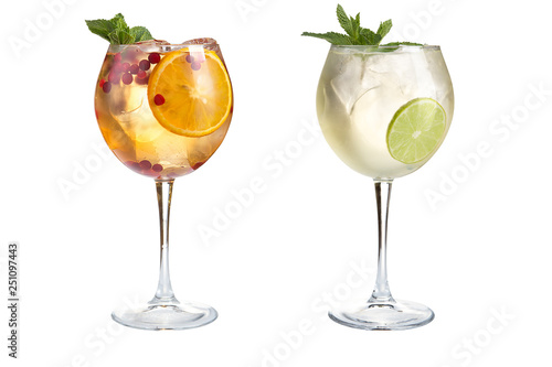 Two light alcoholic or non-alcoholic cocktails with mint, fruits and berries on a white background. Cocktails in glass goblets.