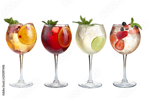Alcoholic and non-alcoholic refreshing cocktails with mint, fruits and berries on a white background. Four cocktails in glass goblets with a long stem.
