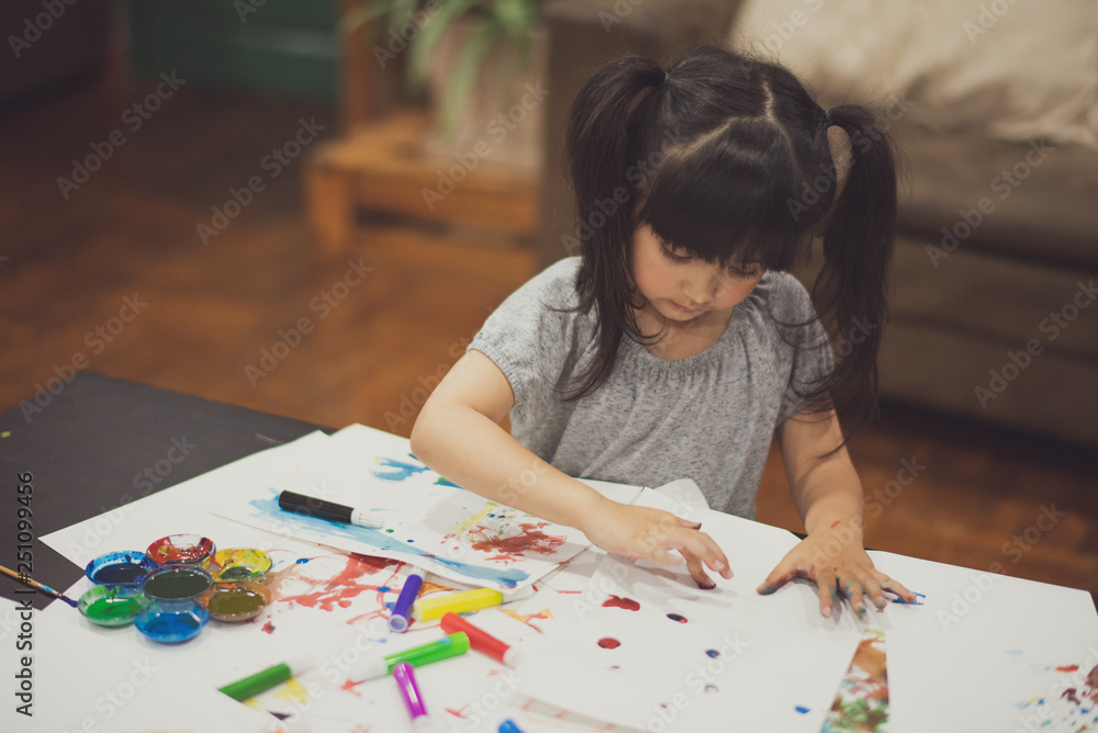 Portrait of cute little girl create art on paper with colored paint on the table at home. Concept of education. Portrait of cute little girl create art on paper with colored paint on the table at home. Concept of education.