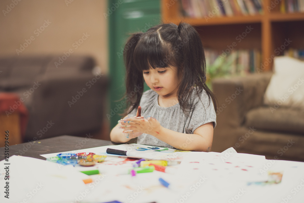 Portrait of cute little girl create art on paper with colored paint on the table at home. Concept of education. Portrait of cute little girl create art on paper with colored paint on the table at home. Concept of education.
