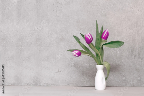 Fototapeta Naklejka Na Ścianę i Meble -  bouquet of tulips in a vase against a concrete wall