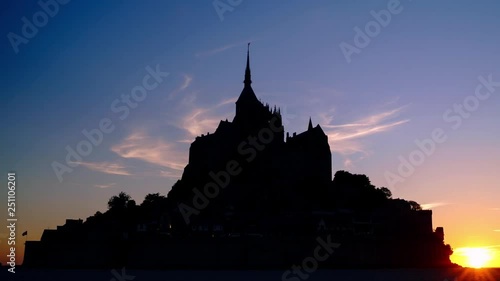 Amazing timelapse video of silhouette of Mont Saint-Michel over beautiful sunset sky.