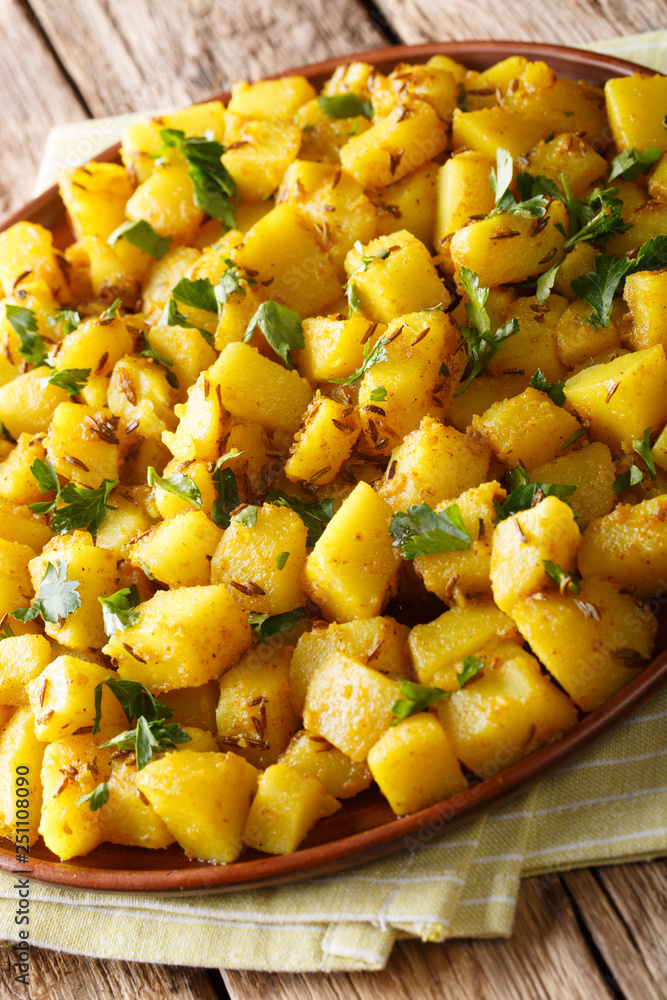 Delicious Indian potatoes Jeera Aloo with spices close-up on a plate. vertical Delicious Indian potatoes Jeera Aloo with spices close-up on a plate. vertical