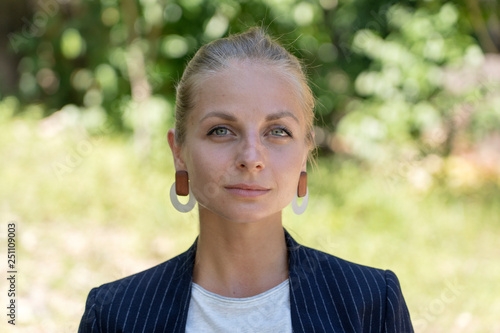 Beautiful caucasian blonde girl in a business suit in nature background. A portrait of a young business woman in tropical garden, Thailand