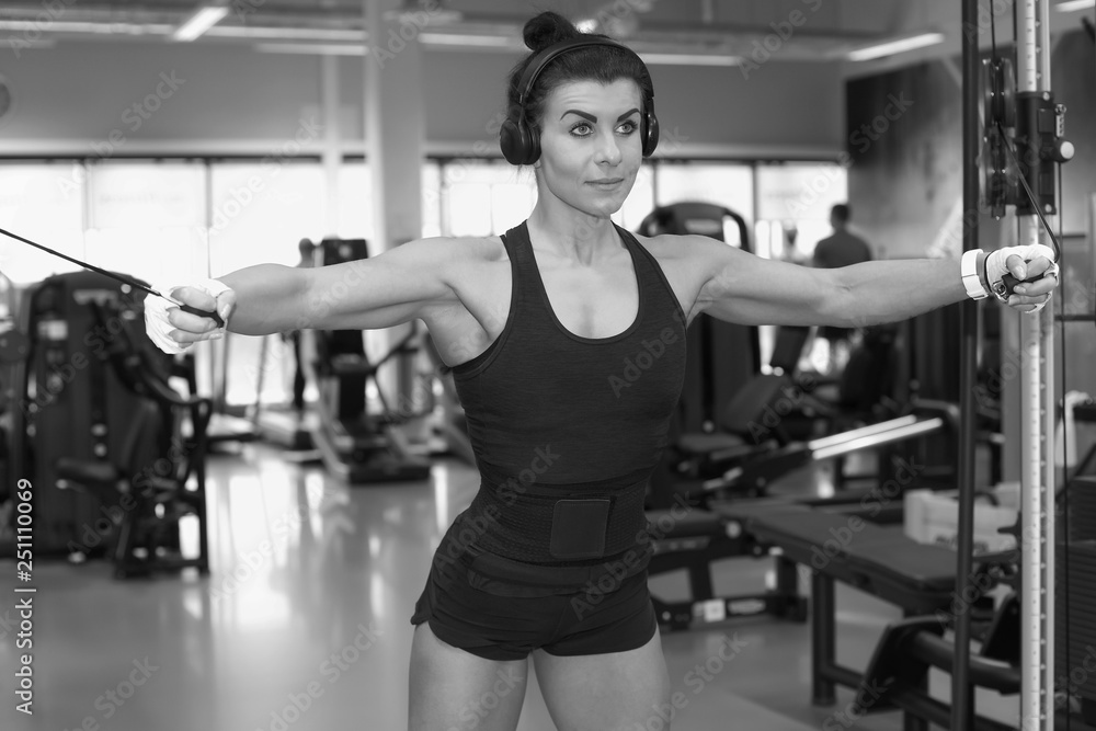 Fototapeta premium Fitness young girl in the gym doing exercises