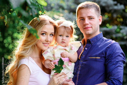 Happy family and they dauther walking in spring park and have a nice time