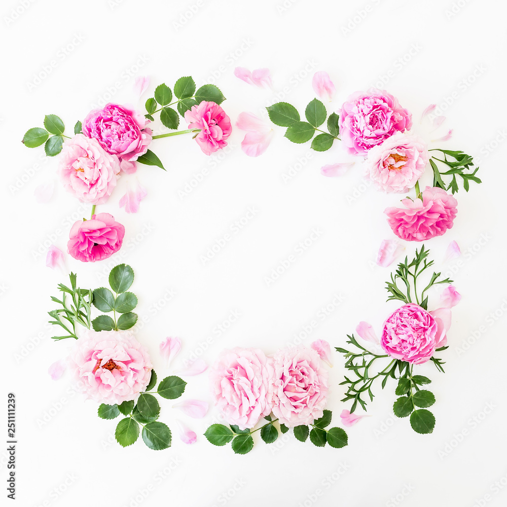 Floral frame of pink roses and leaves on white background. Flat lay, top view.