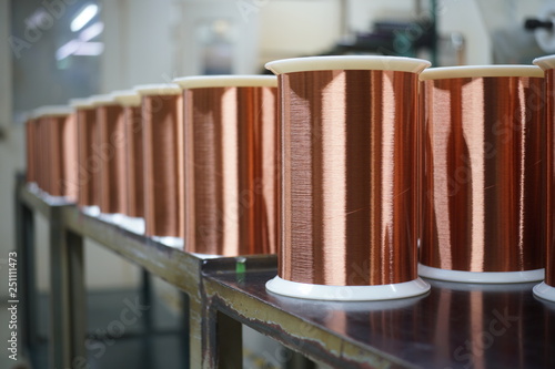 Fotografie Standard copper wire enamel in a bobbin on the table, steel floor in the factory