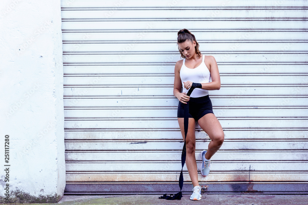 Strong girl in front of garage door with dox gloves prepare for exercise Strong girl in front of garage door with dox gloves prepare for exercise