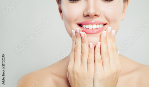 Young woman face closeup. Pink glossy female lips with natural makeup and french manicure hands photo