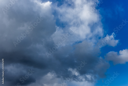 Fototapeta Naklejka Na Ścianę i Meble -  Fluffy white and grey clouds against a bright, colorful blue sky
