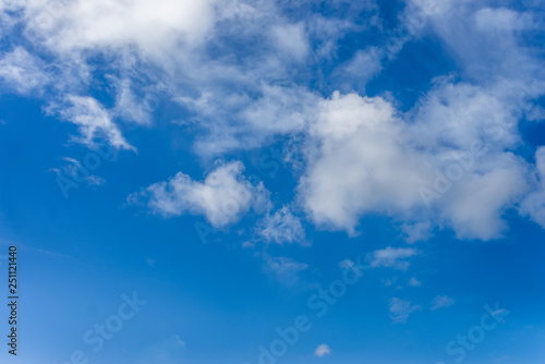 Fluffy white clouds against a bright  colorful blue sky
