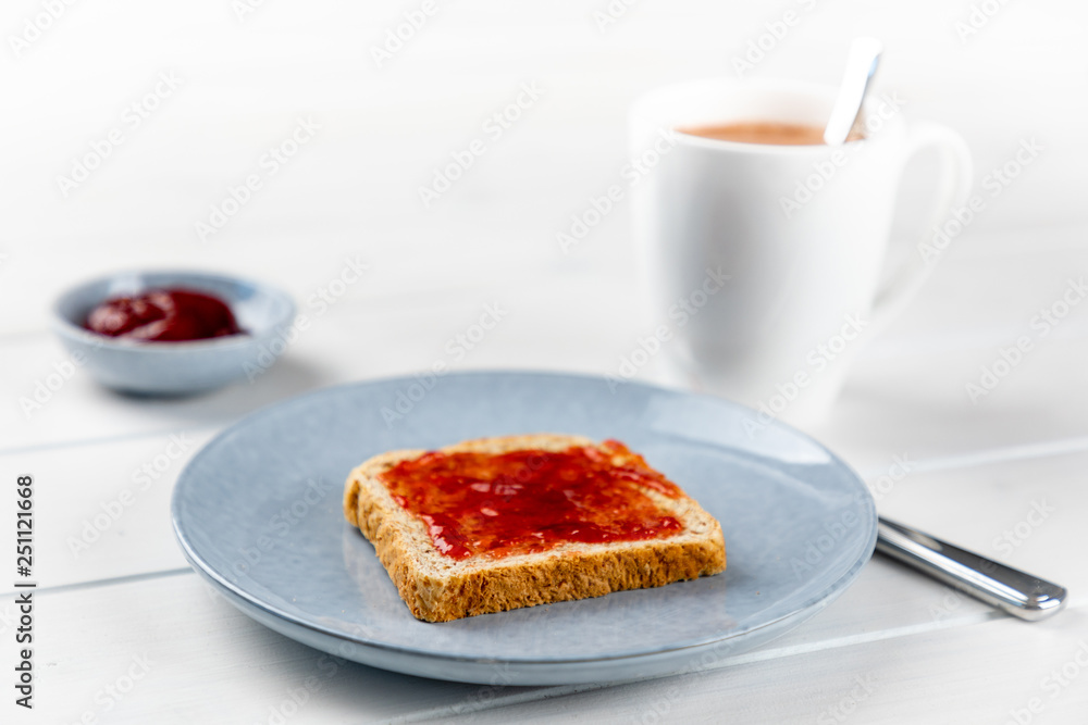 toast with strawberry jam on a blue plate and cup of cocoa toast with strawberry jam on a blue plate and cup of cocoa