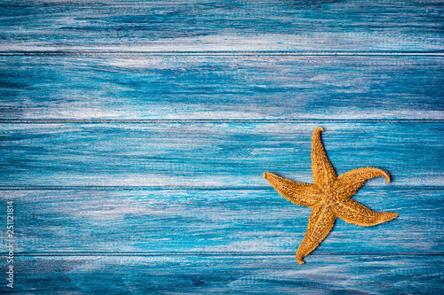 Starfish on blue background as concept of vacation time