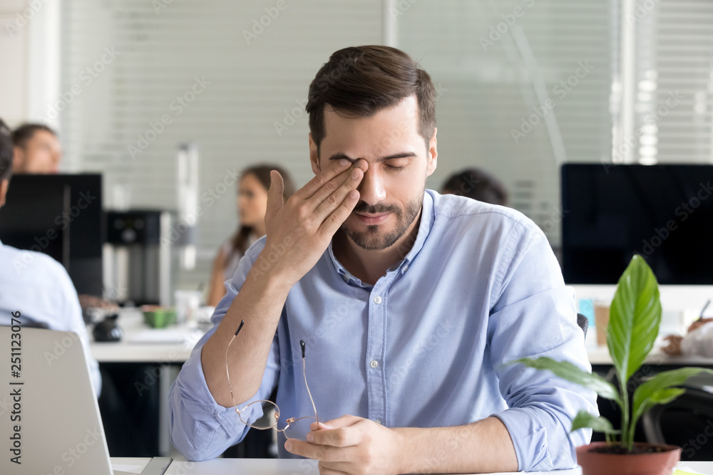Fototapeta premium Office worker taking off glasses rubbing tired eyes 