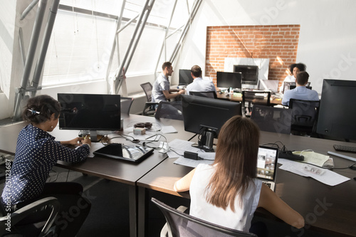 Diverse employees working in coworking open space 